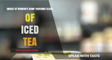 Refreshing Moment: Woman’s Hand Gently Touching a Glass of Iced Tea